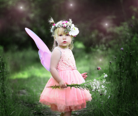 Little girl in the garden dressed as a fairy