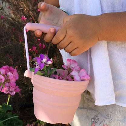 Child holding Scrunch Seedling Pot with flowers