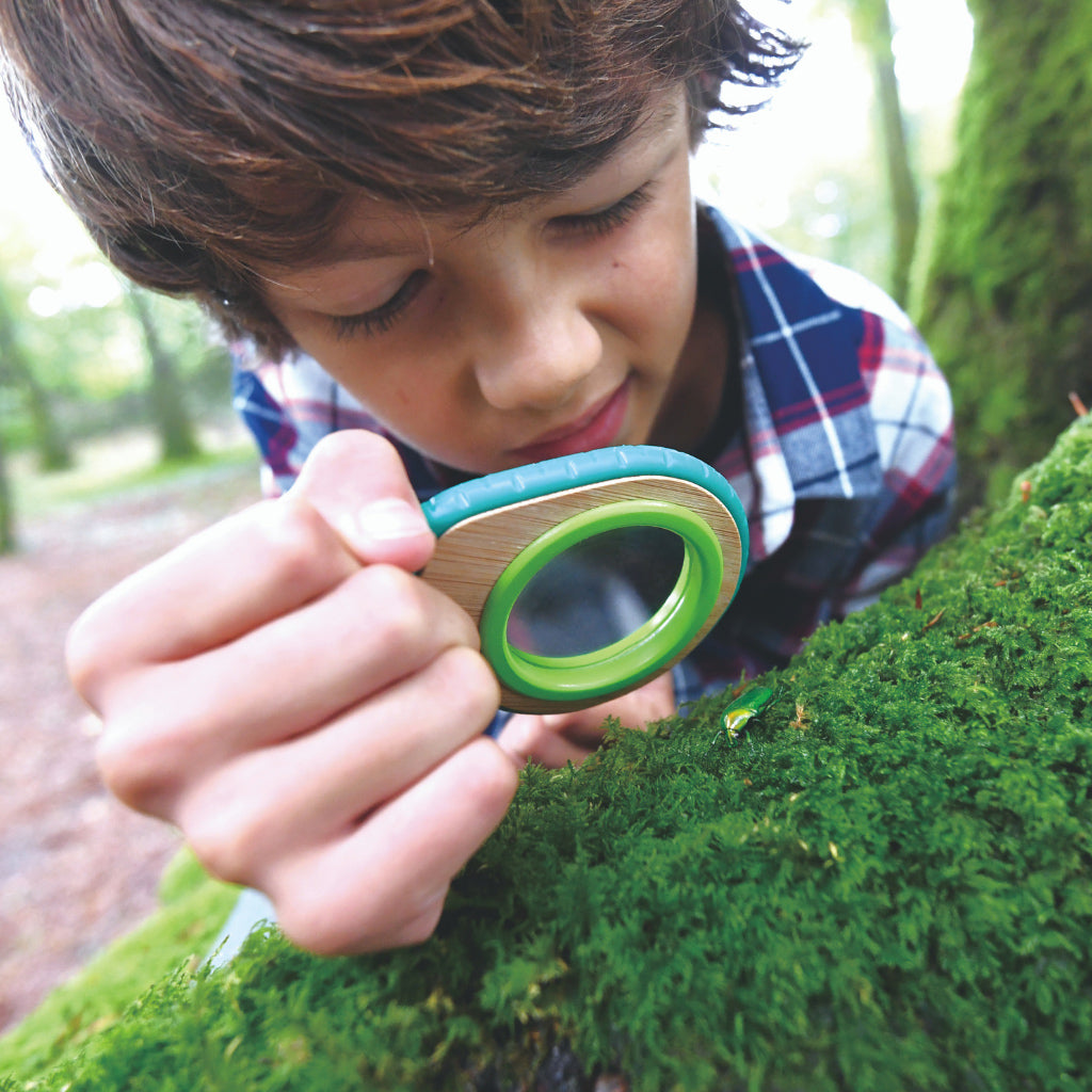 Boy using the childs magnifying glass from the Hape kids explorer kit
