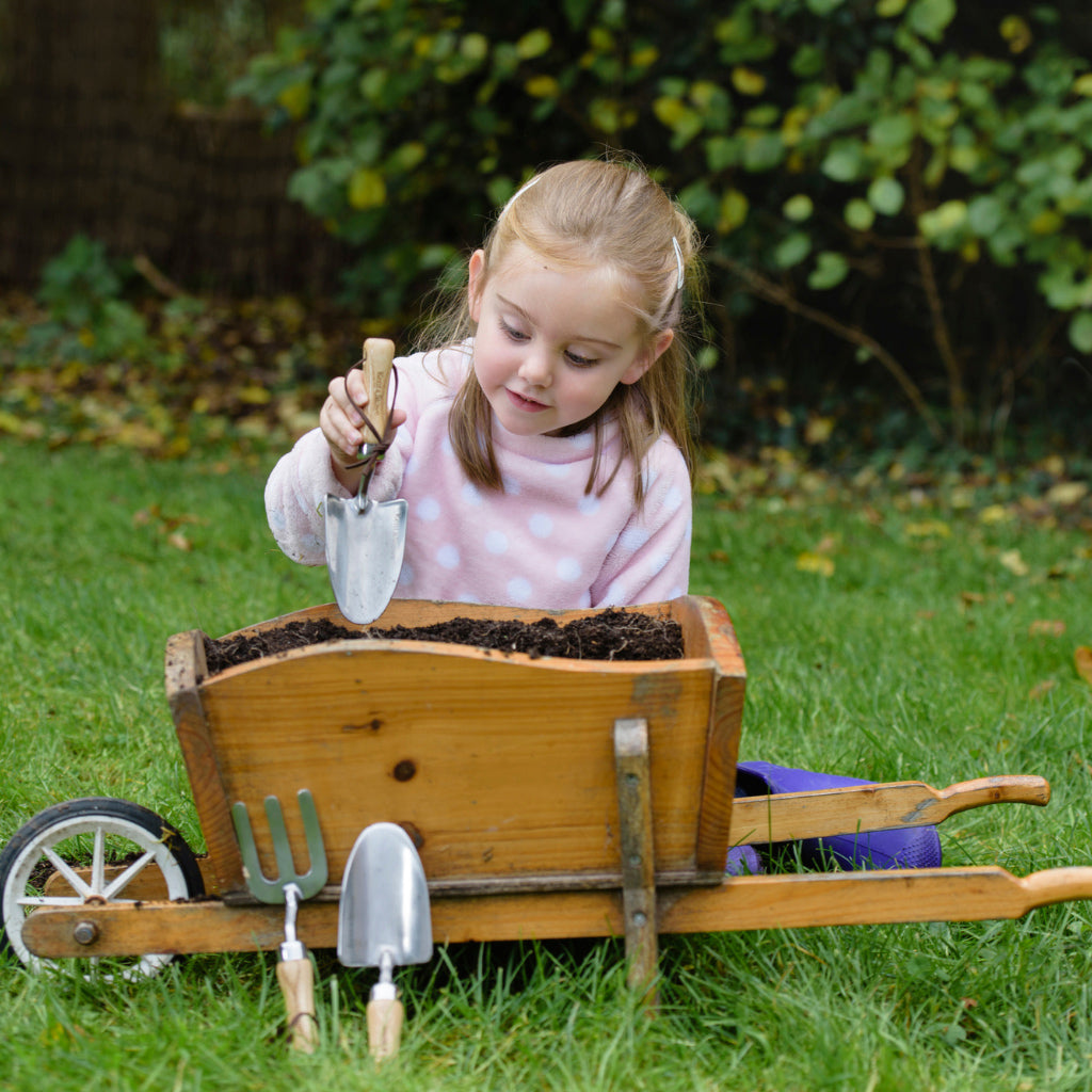 Girl using the Kent and Stowe gardening trowel for kids