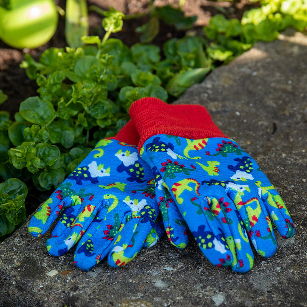 Kent and Stowe gardening gloves for children in blue with dinosaur resting on garden step